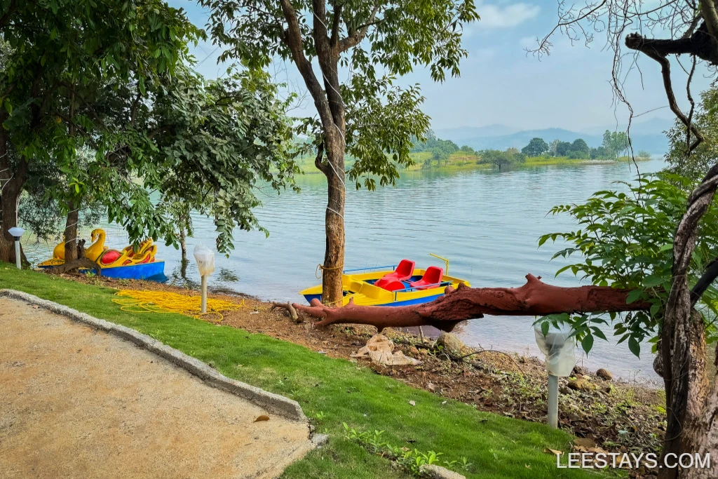 Scenic view at Diamond Resort, featuring colorful paddle boats by Pawna Lake surrounded by lush greenery and tranquil waters.