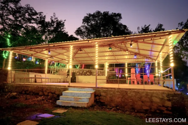 A beautifully lit pavilion at Diamond Resort near Pawna Lake, surrounded by lush greenery and evening lights.