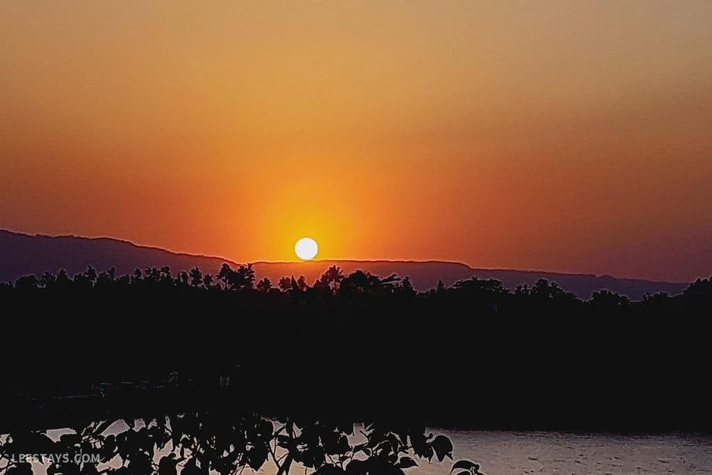A stunning sunset viewed from a resort in Kamshet, featuring vibrant orange hues against a serene landscape.
