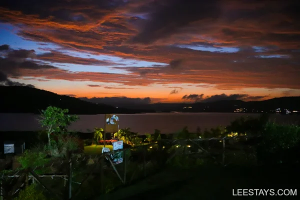 Scenic view of Pawna Lake at sunset, featuring dramatic clouds and surrounding greenery, perfect for a relaxing stay.