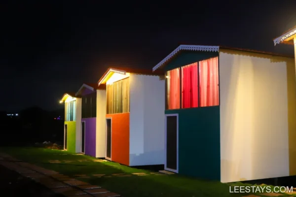 Brightly colored accommodations with illuminated features at Pawna Lake, creating an inviting atmosphere at night.