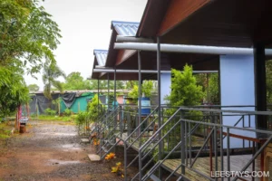 Family cottages near Pawna Lake, featuring a scenic pathway surrounded by greenery and a peaceful atmosphere.