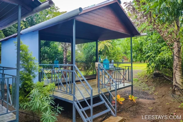 A cozy cottage surrounded by greenery near Pawna Lake, ideal for family getaways with outdoor seating and a welcoming atmosphere.