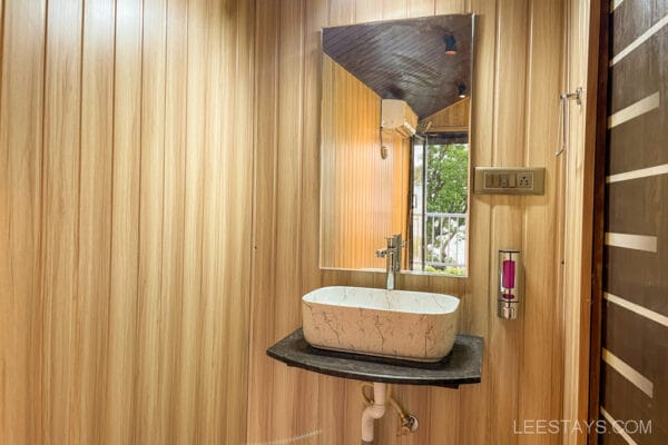 Interior of a cottage near Pawna Lake, featuring a modern sink and mirror, ideal for a couple's getaway.