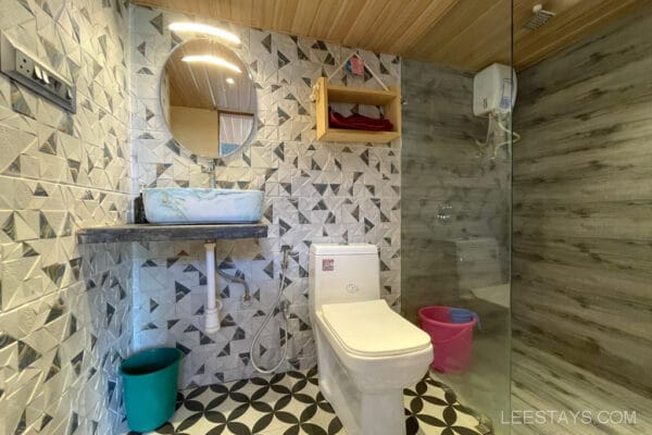 Bathroom with geometric tiles, a glass shower partition, and a modern sink located in glass rooms near Pawna Lake.